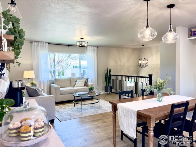 237 Clover Ln, Fort Collins, CO 80521 - dining area with a chandelier, wood finished floors, and a textured ceiling