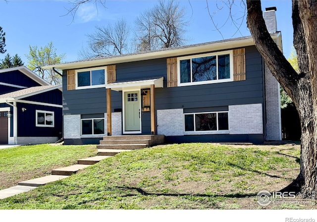 237 Clover Ln, Fort Collins, CO 80521 - bi-level home featuring brick siding, a front lawn, entry steps, and a chimney