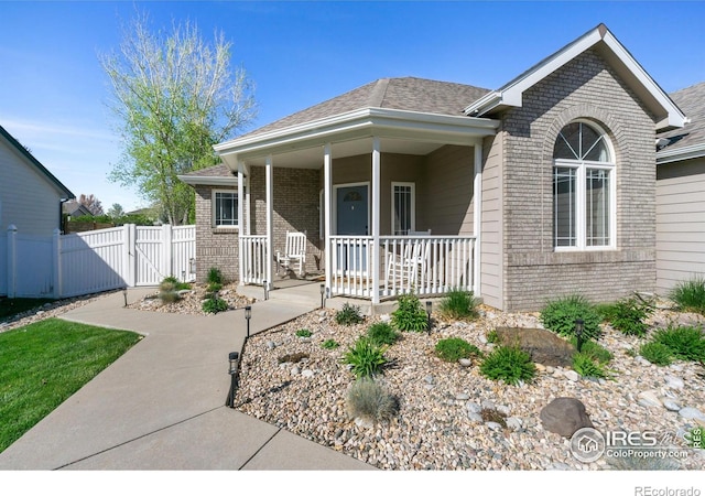 112 Cobble Dr, Windsor, CO 80550 - view of front of property with covered porch, brick siding, a gate, and fence