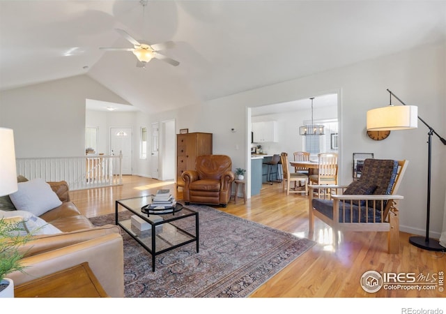 112 Cobble Dr, Windsor, CO 80550 - living area with lofted ceiling, wood finished floors, and ceiling fan with notable chandelier