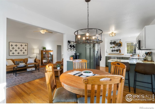 112 Cobble Dr, Windsor, CO 80550 - dining room with ceiling fan with notable chandelier and light wood-type flooring