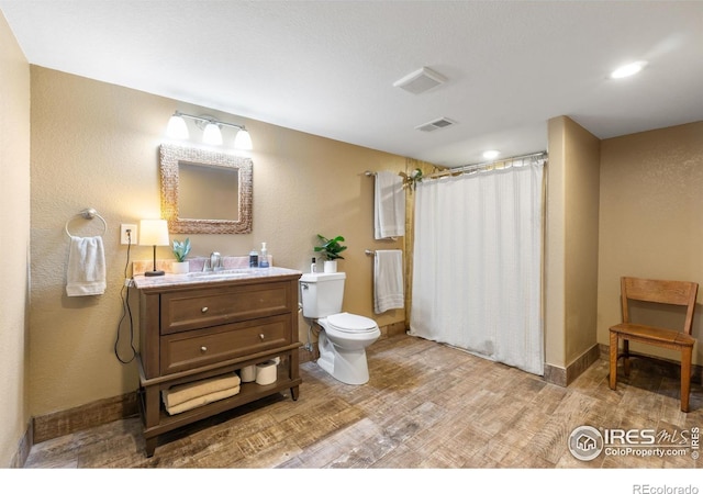 112 Cobble Dr, Windsor, CO 80550 - bathroom with toilet, a shower with curtain, wood finished floors, vanity, and visible vents