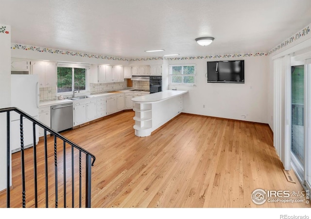 kitchen featuring white cabinetry, appliances with stainless steel finishes, decorative backsplash, and a sink