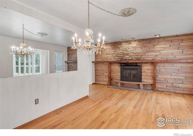 1629 Timber Ln, Boulder, CO 80304 - unfurnished living room with a chandelier, wood-type flooring, and a stone fireplace