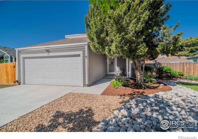 view of front of house featuring fence, a garage, and driveway