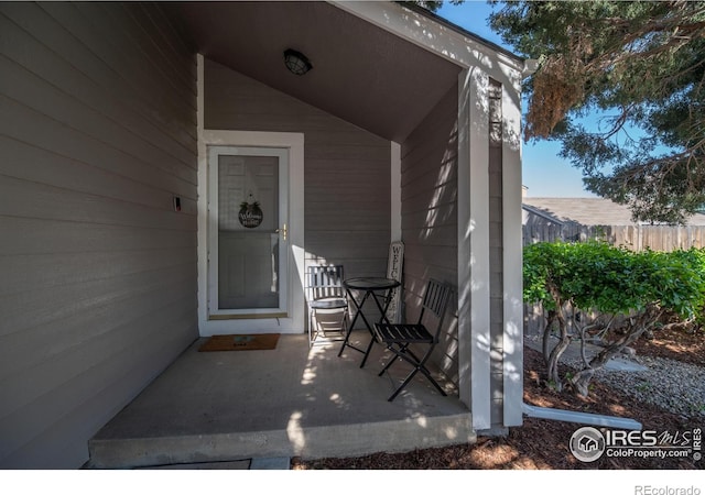 view of patio featuring a porch and fence