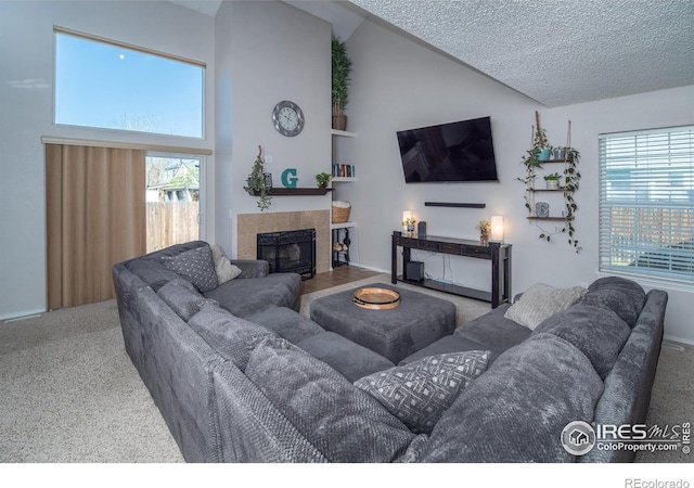 living room featuring a wealth of natural light, high vaulted ceiling, a fireplace, and carpet floors