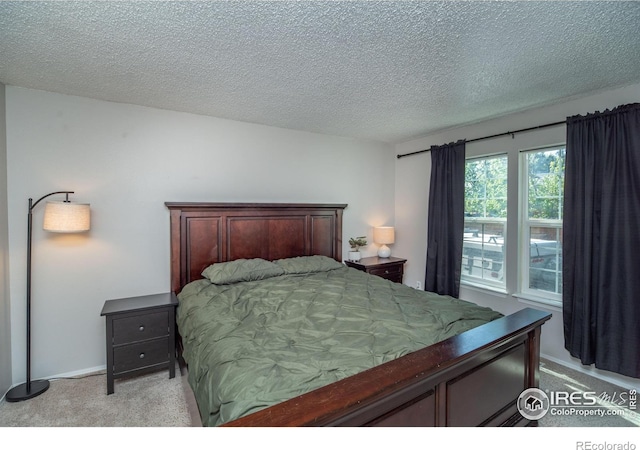bedroom featuring light colored carpet and a textured ceiling