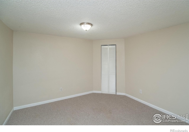 empty room with carpet and baseboards