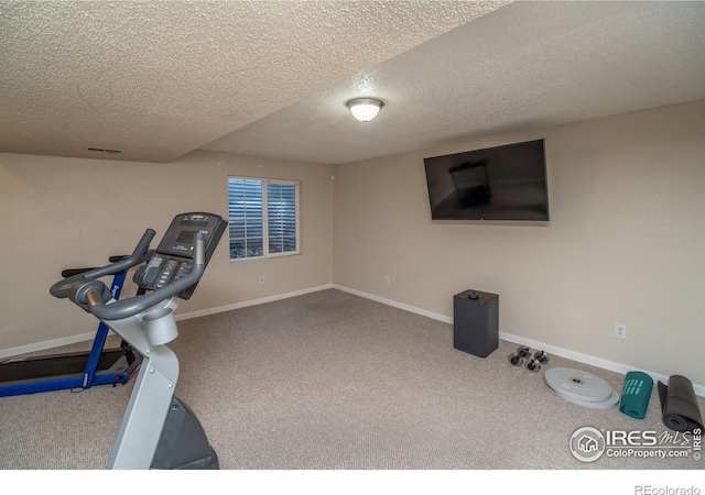 workout area with a textured ceiling, carpet, baseboards, and visible vents