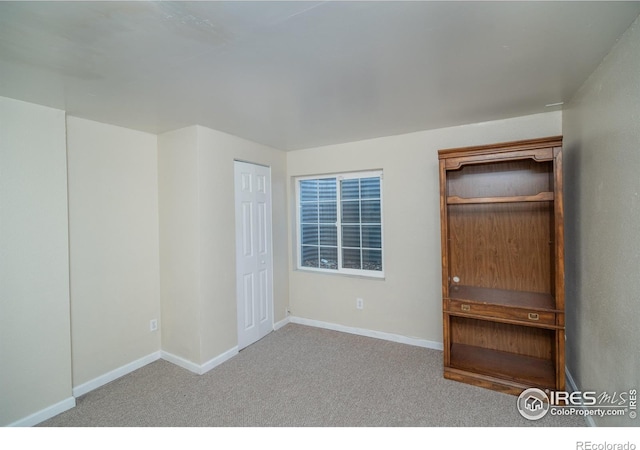 unfurnished bedroom featuring carpet flooring and baseboards