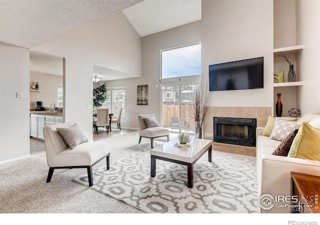 87 Macon Ct, Aurora, CO 80010 - living area featuring high vaulted ceiling, a tiled fireplace, and carpet floors
