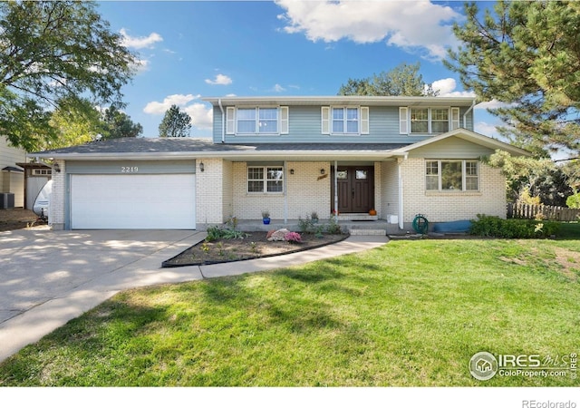 traditional-style home featuring concrete driveway, an attached garage, brick siding, and a front yard