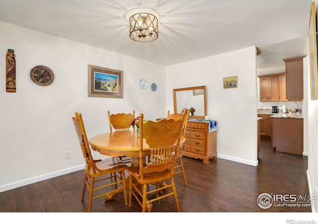 dining area featuring dark wood-style flooring and baseboards