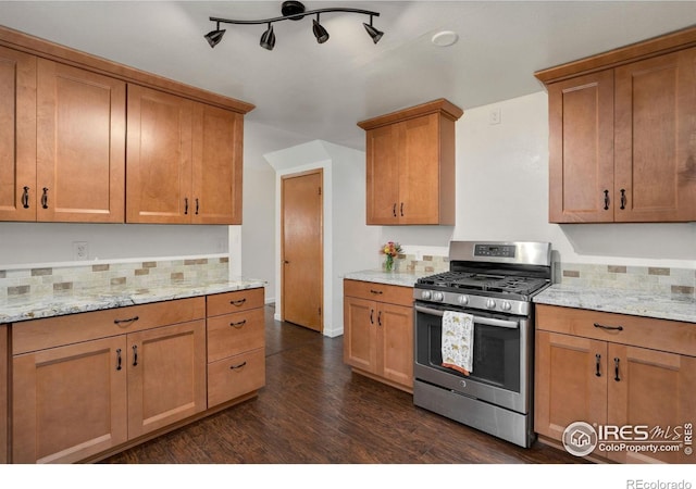 kitchen with stainless steel gas range, dark wood-style flooring, brown cabinets, and decorative backsplash