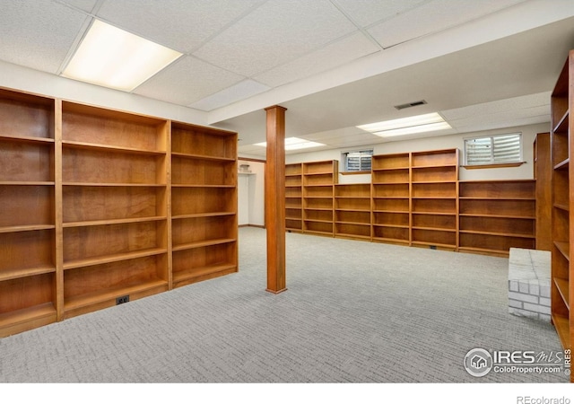 finished below grade area featuring carpet flooring, visible vents, and a paneled ceiling