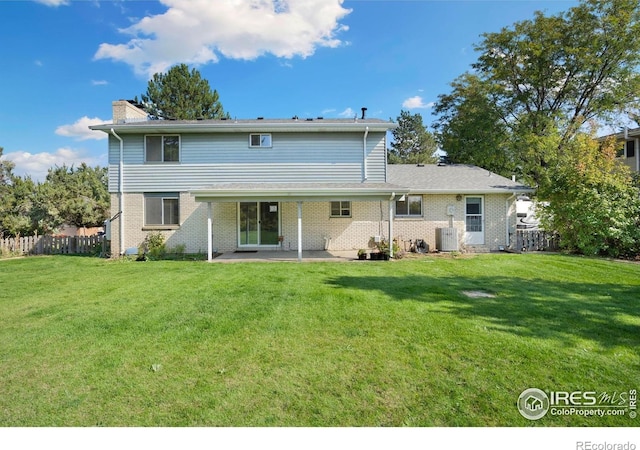 back of house with a chimney, a yard, a patio, and fence