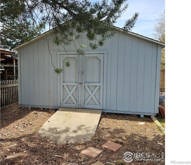 view of shed featuring fence