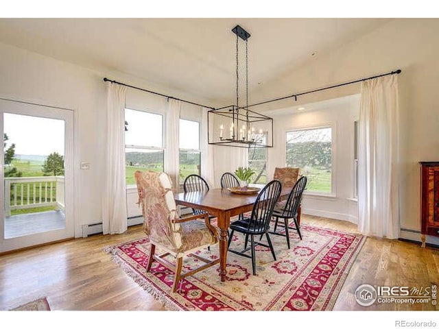 dining space featuring light wood-type flooring and a chandelier