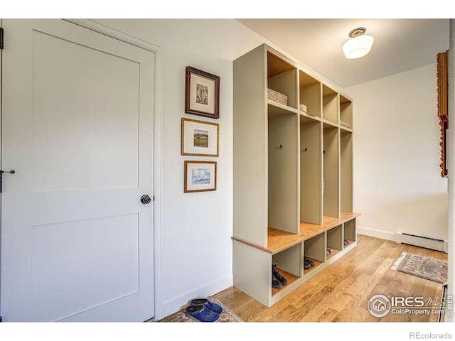 mudroom featuring a baseboard heating unit, light wood finished floors, and baseboards