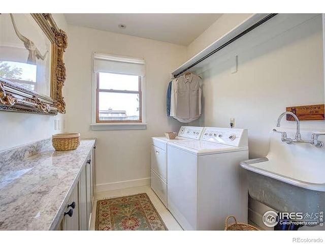 laundry room featuring washing machine and dryer, cabinet space, and baseboards