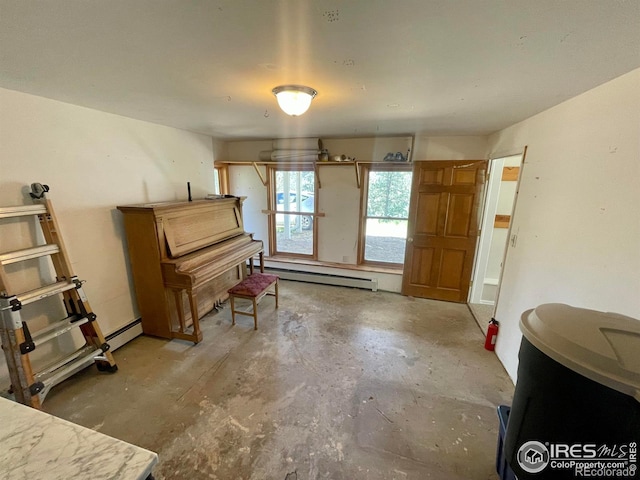 miscellaneous room with baseboard heating, concrete flooring, and a baseboard radiator