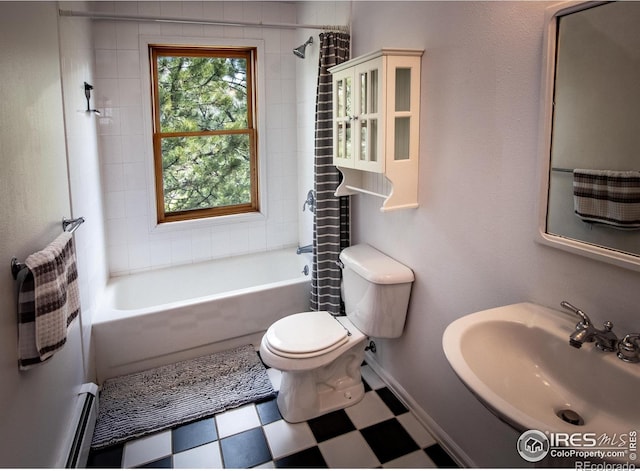 full bath with tile patterned floors, a sink, toilet, a baseboard heating unit, and shower / bath combo