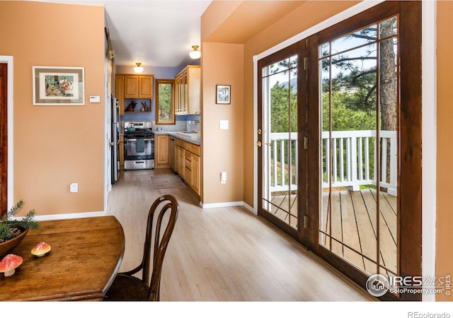 doorway to outside featuring light wood-style flooring and baseboards