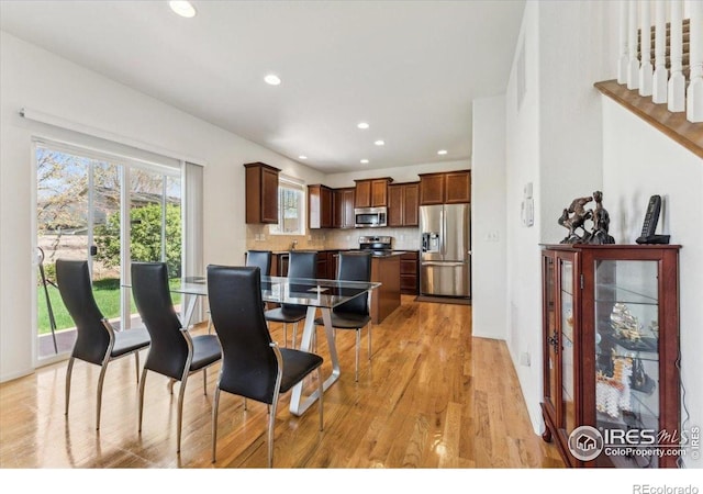 dining space with light wood-style floors and recessed lighting