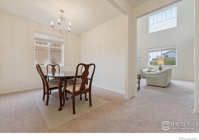 dining room with carpet, a chandelier, and baseboards