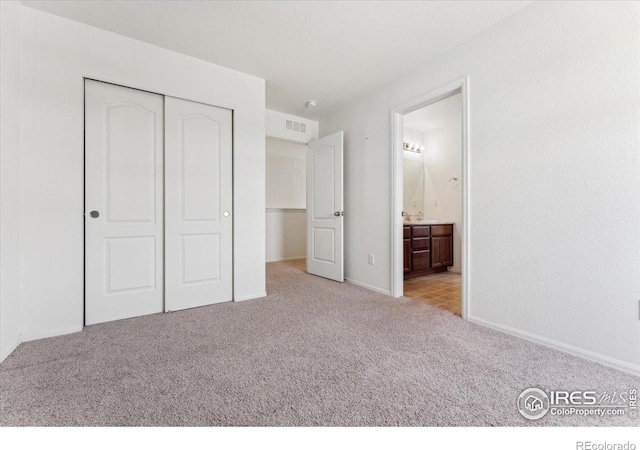 unfurnished bedroom featuring carpet flooring, connected bathroom, a closet, visible vents, and baseboards