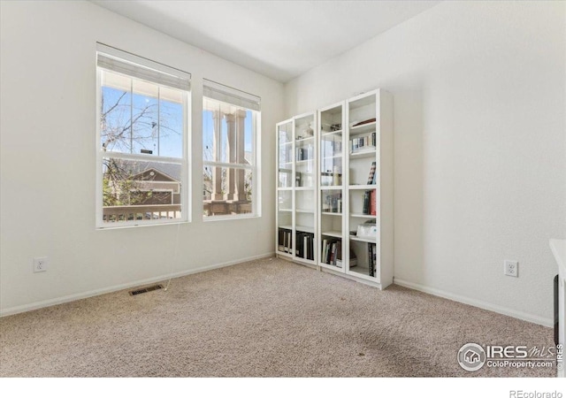 empty room with visible vents, baseboards, and carpet floors