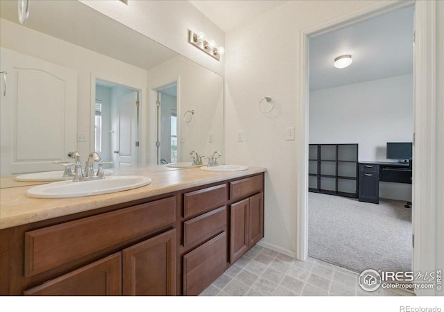 bathroom with double vanity and baseboards