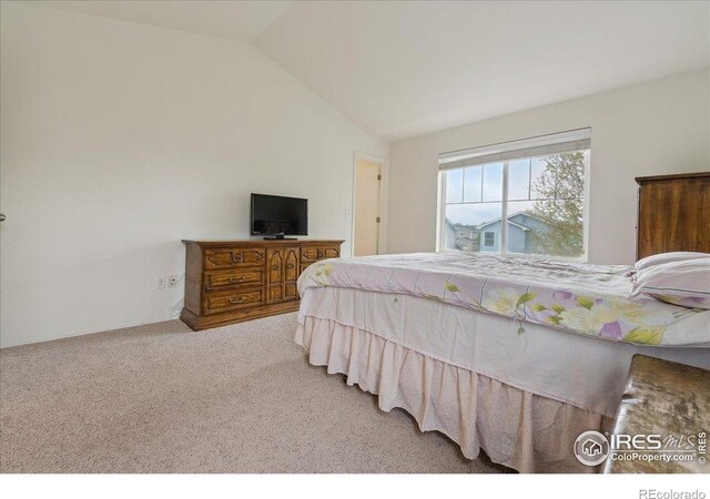 carpeted bedroom with lofted ceiling