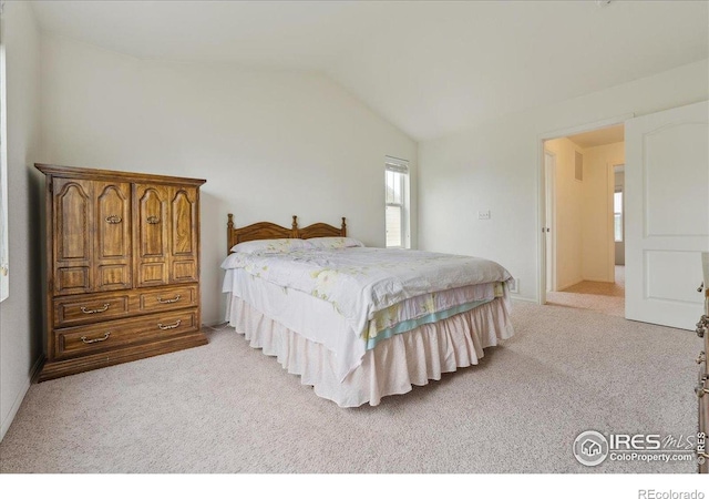 bedroom featuring light carpet and vaulted ceiling