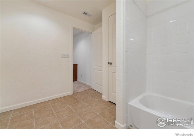 full bathroom with a tub to relax in, tile patterned flooring, and baseboards