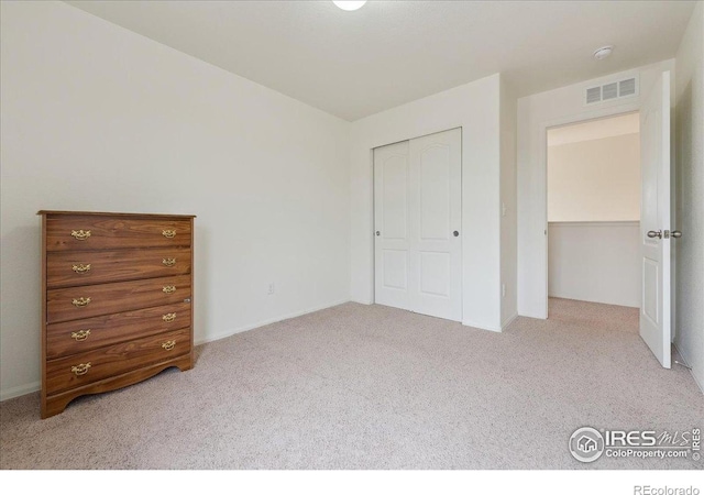 unfurnished bedroom with carpet floors, a closet, and baseboards