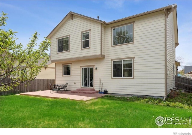 back of property with entry steps and a patio