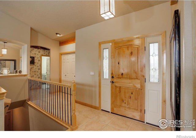 foyer entrance with baseboards and light tile patterned floors