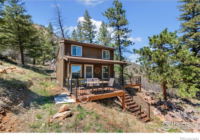 view of front of house featuring stairway and a wooden deck