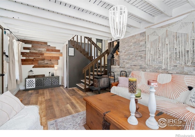 living room with beam ceiling, stairway, and wood finished floors