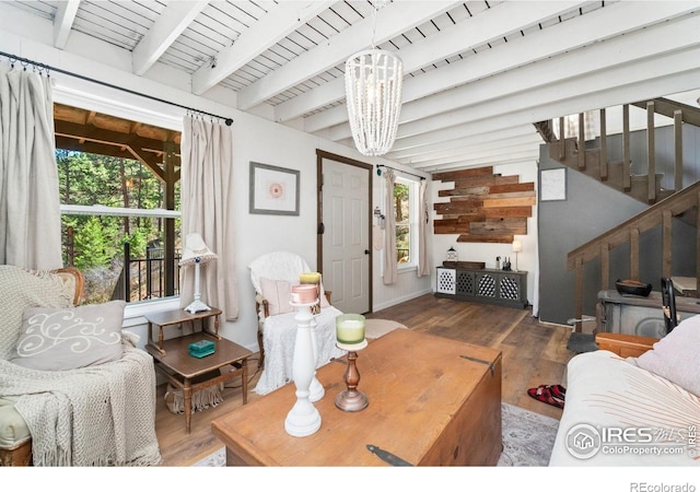 living room featuring stairway, a chandelier, beam ceiling, and wood finished floors