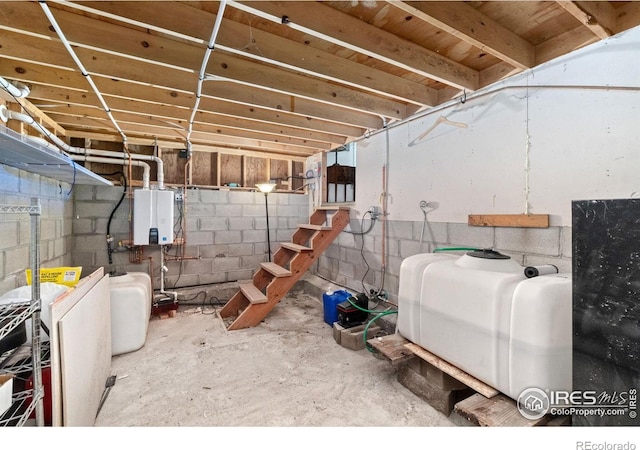 unfinished below grade area with tankless water heater and concrete block wall