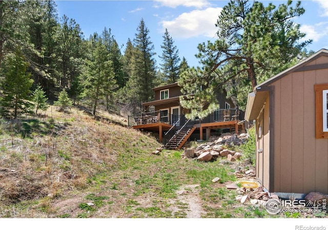 rear view of property with stairway and a wooden deck