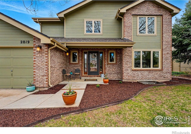 view of front facade featuring brick siding and a garage