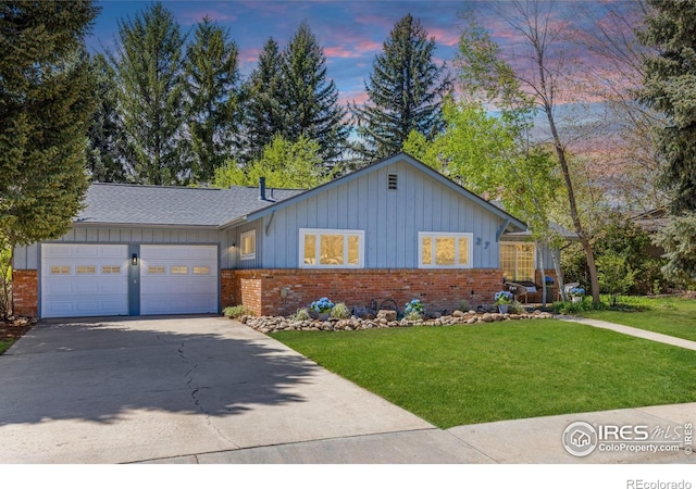 ranch-style home featuring a garage, concrete driveway, board and batten siding, a front lawn, and brick siding