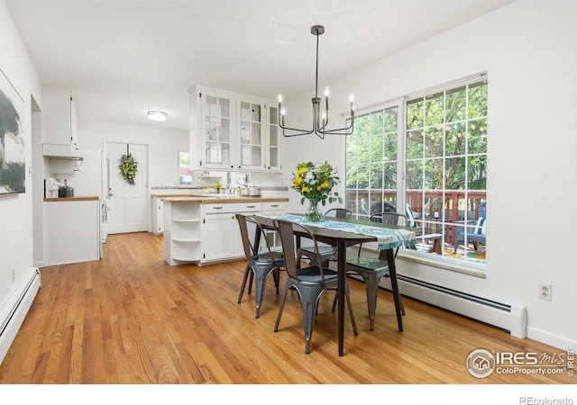 dining room featuring baseboard heating, an inviting chandelier, and light wood-style flooring
