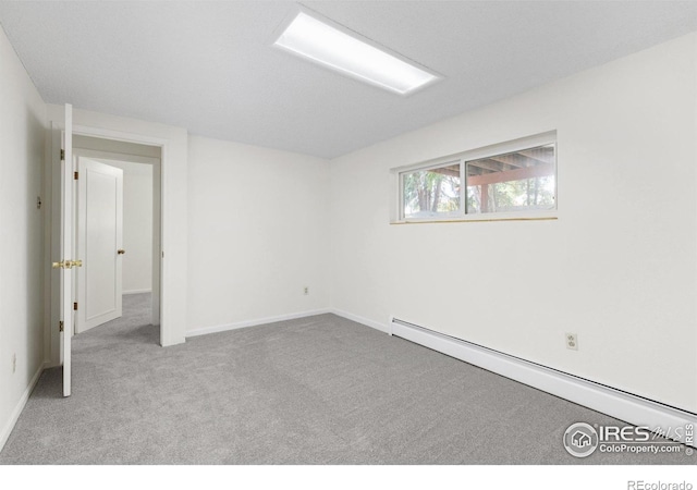 unfurnished room featuring carpet, baseboards, and a baseboard heating unit