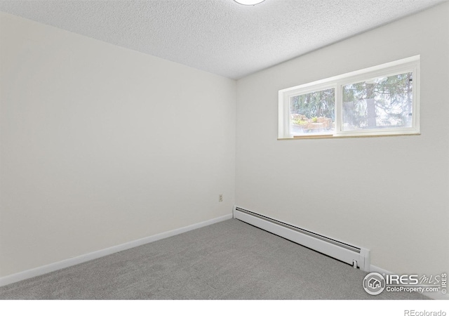 carpeted empty room with baseboards, baseboard heating, and a textured ceiling