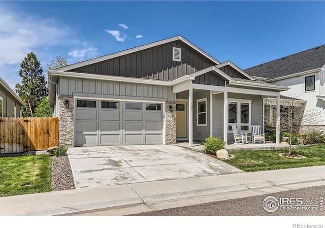 craftsman-style house with board and batten siding, fence, a garage, concrete driveway, and a porch
